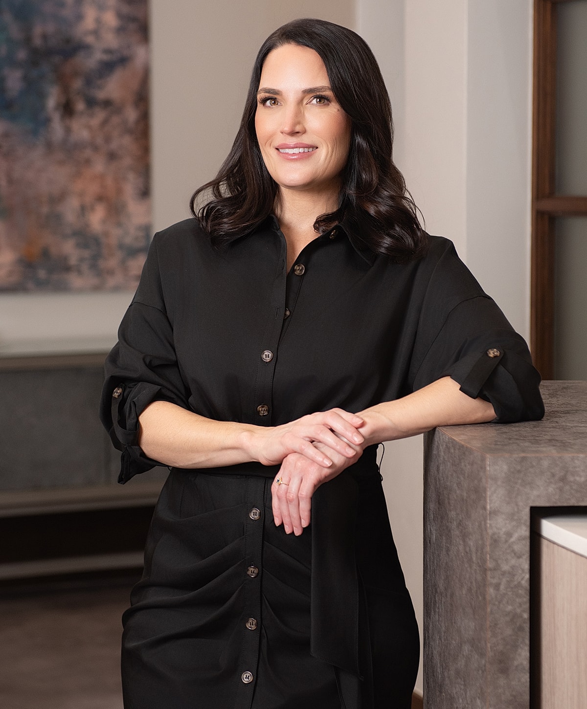 Woman in black shirt posing indoors.