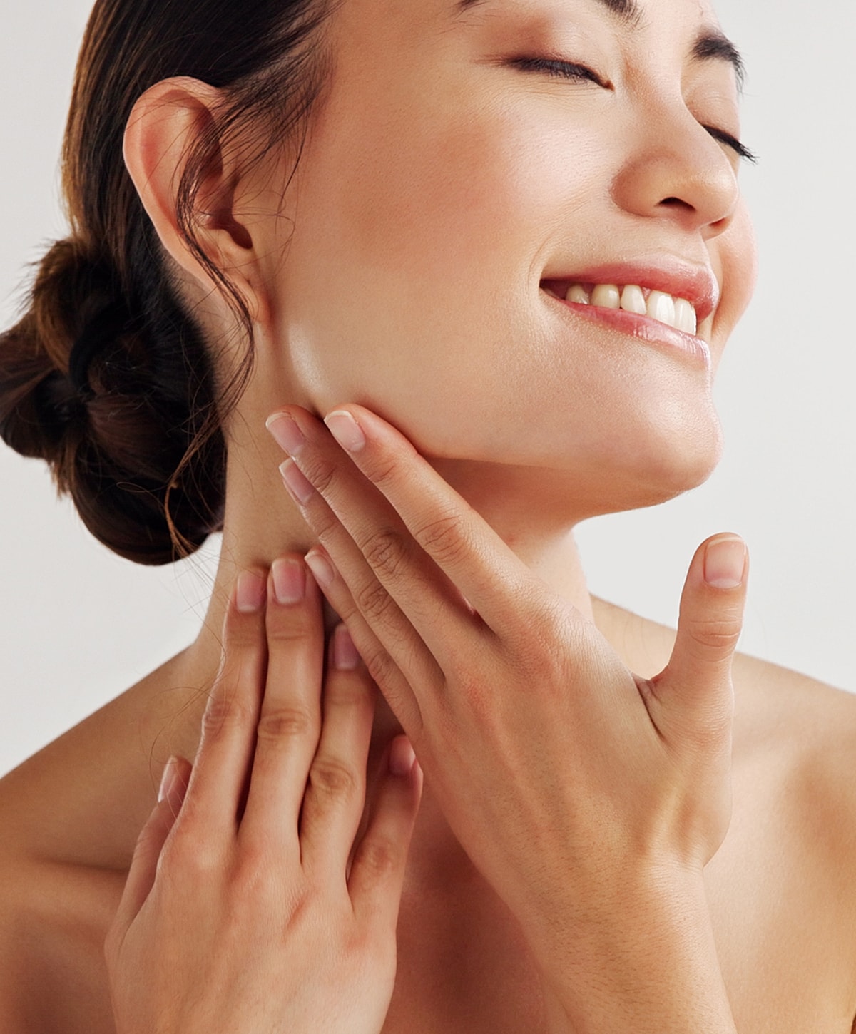 Smiling woman in white lingerie on light background.