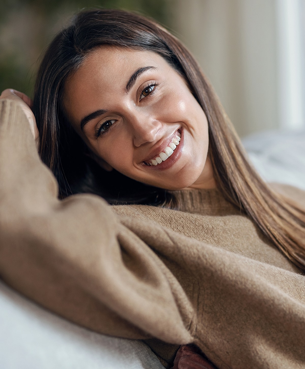 Smiling woman relaxing on a couch.