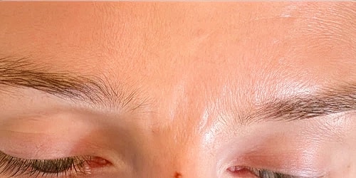 Close-up of eyes and forehead with eyelashes.