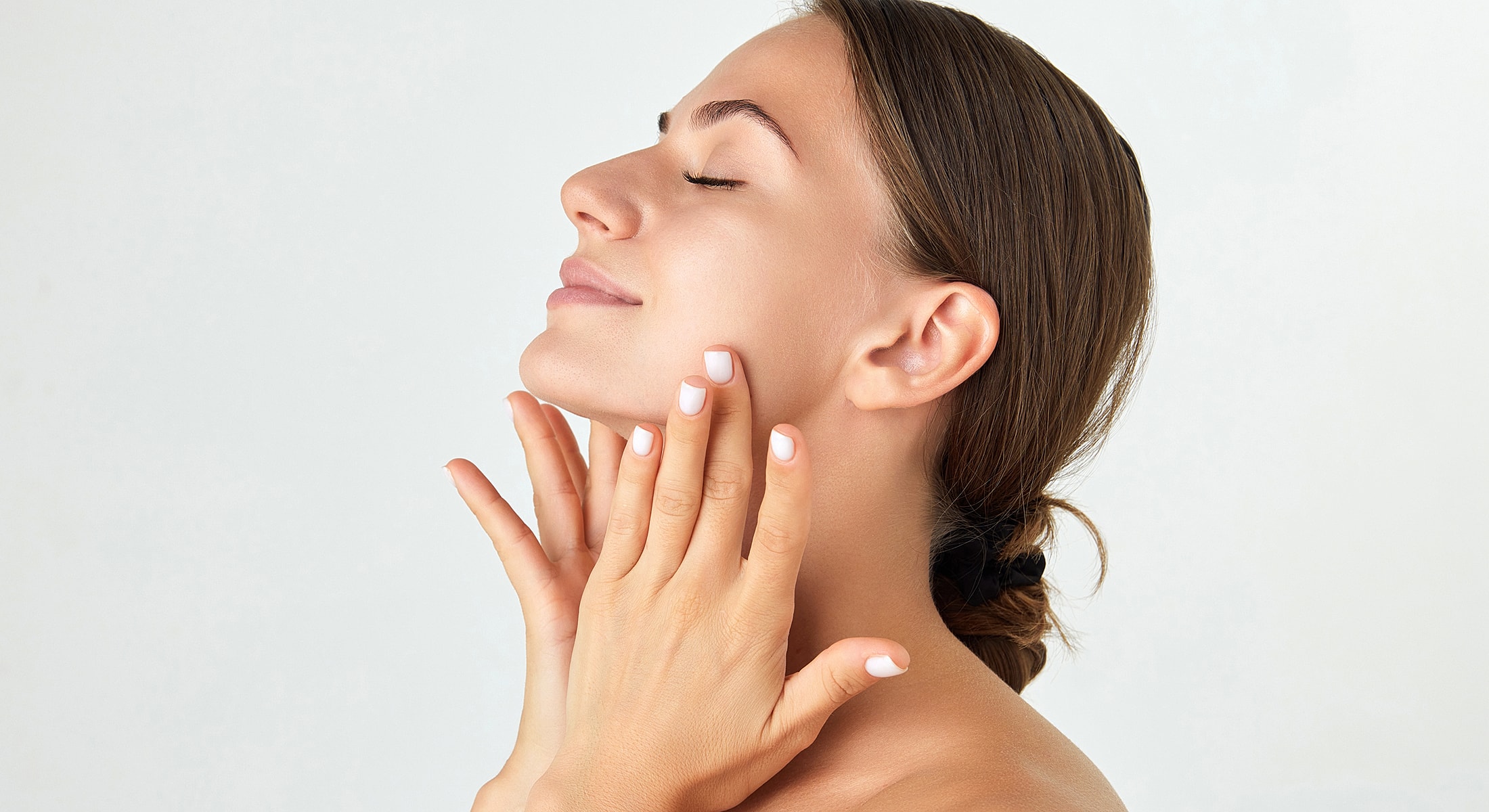 Woman enjoying skincare routine with gentle touch.